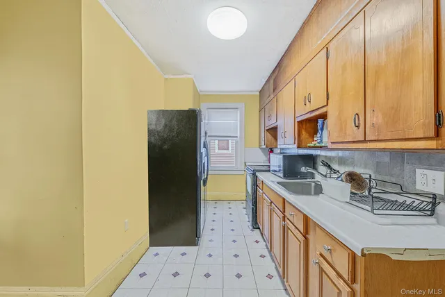 a kitchen with a sink a stove top oven a refrigerator and a window