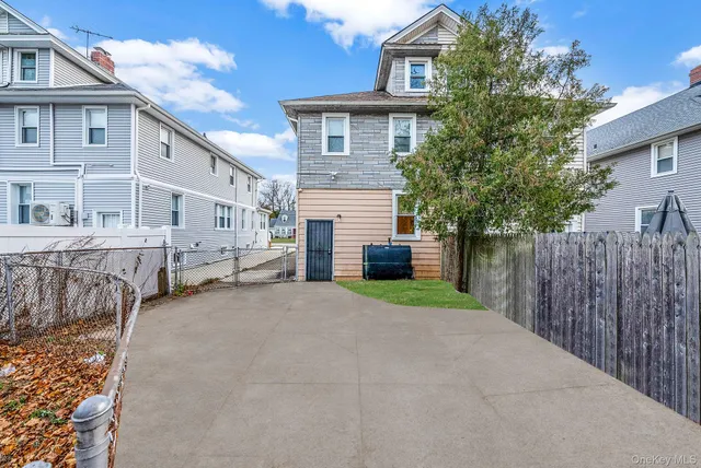a white house that has tree in front of it