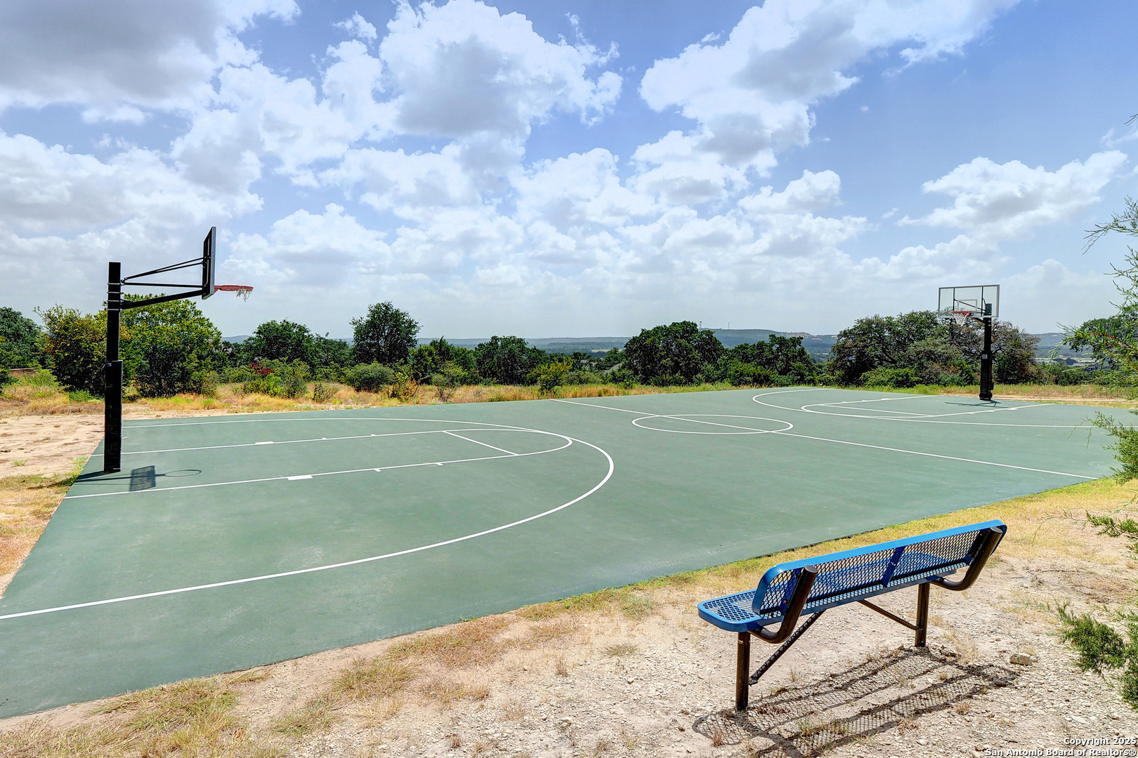 31160 Clover Pass Bulverde, TX 78163 - Photo 8 of 10 a view of a tennis court with a bench in the background