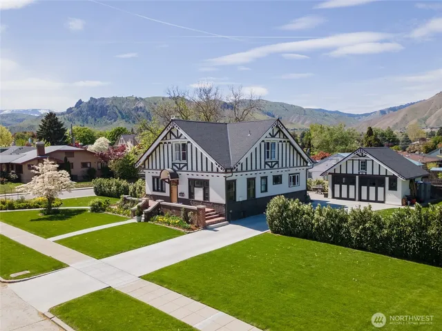 a view of a big house with a big yard and potted plants