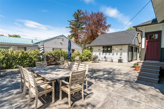 a view of a patio with a table and chairs under an umbrella with a fire pit