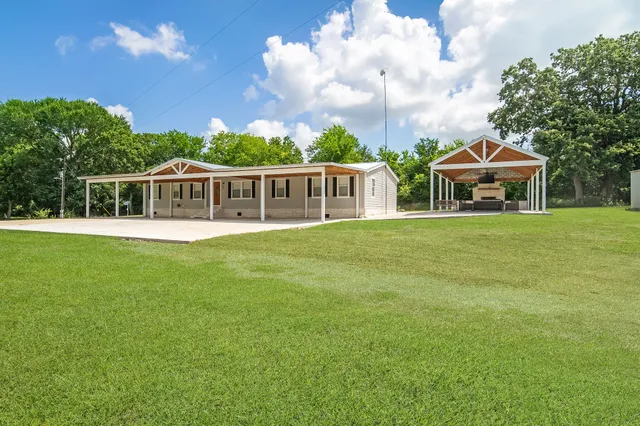a view of a house with a backyard