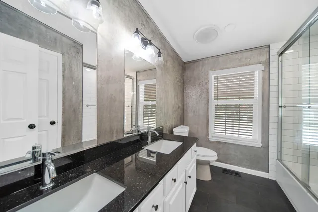 a bathroom with a granite countertop sink and a large mirror