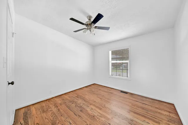 a view of a big room with wooden floor and windows