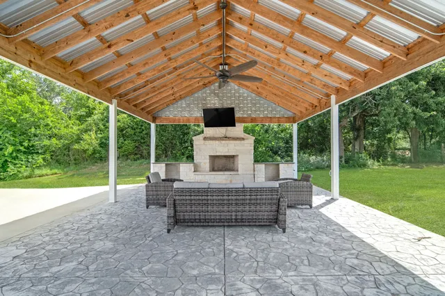 a view of a couches in the patio with a backyard