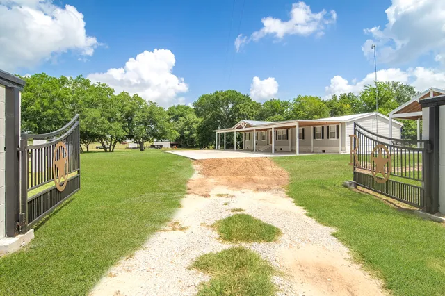 a view of a house with backyard and a garden