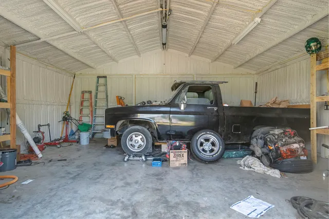 a couple of chairs sitting in big yard with large trees