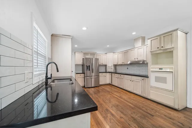 a kitchen with stainless steel appliances granite countertop a sink and a stove top oven