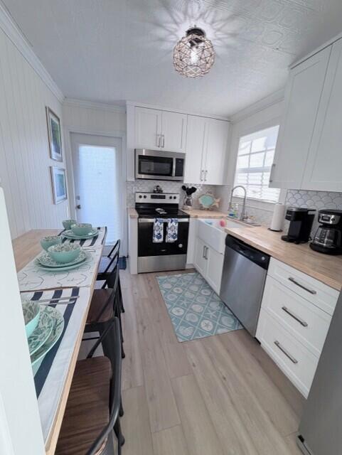 91 Treasure Boulevard Key Largo, FL 33037 - Photo 4 of 20 a kitchen with a stove a sink a kitchen island with chairs and wooden floor