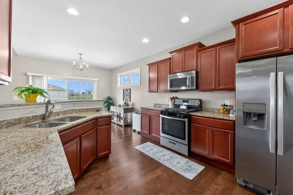 a kitchen with stainless steel appliances granite countertop a refrigerator a stove top oven a sink and dishwasher