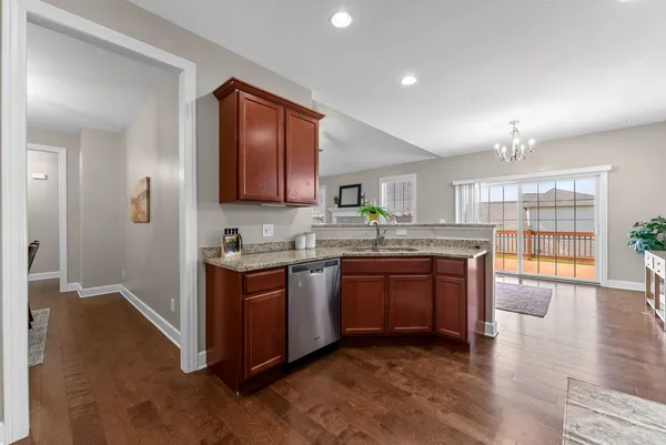 a large kitchen with stainless steel appliances granite countertop a stove and a wooden floors