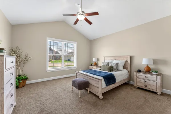a spacious bedroom with a bed a chandelier and a window