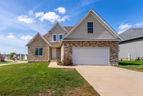 a front view of a house with a yard and garage