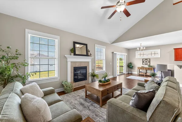a living room with furniture fireplace and a large window