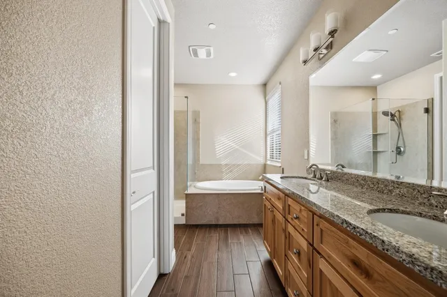 a bathroom with a granite countertop sink mirror and a bathtub