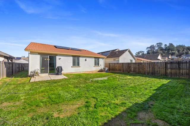 a backyard of a house with table and chairs