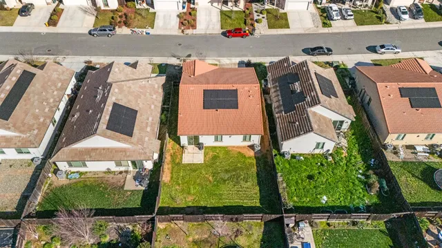 an aerial view of residential houses with outdoor space and ocean view