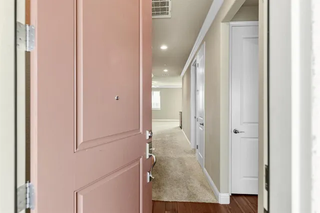 a view of a hallway with toilet and a bathroom
