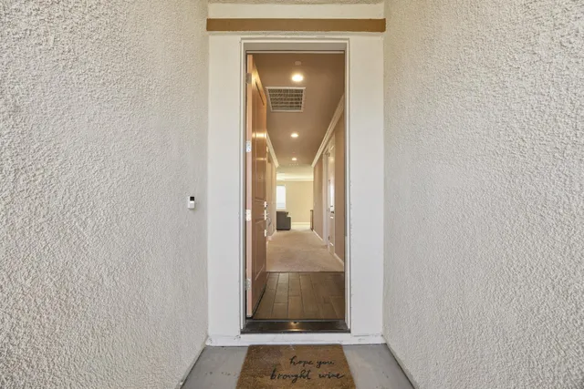 a view of a hallway with wooden floor and a livingroom