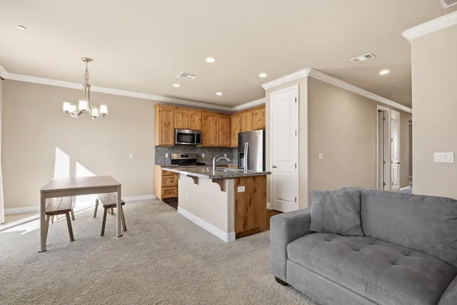 a living room with furniture and kitchen chandelier