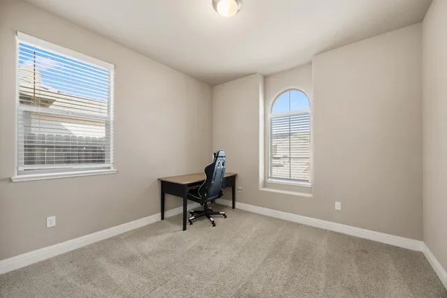 a view of a workspace with furniture and a window