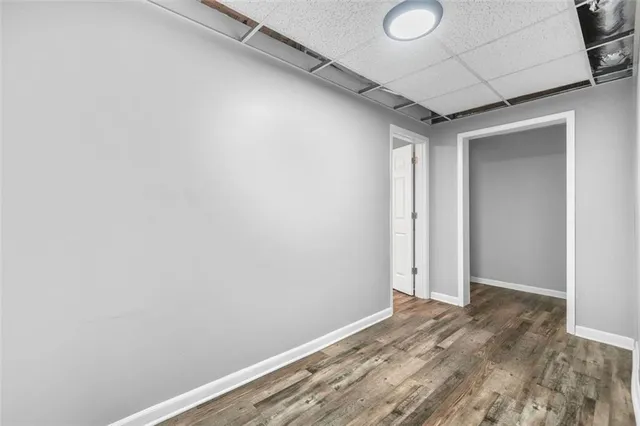 a view of a hallway with wooden floor and a kitchen