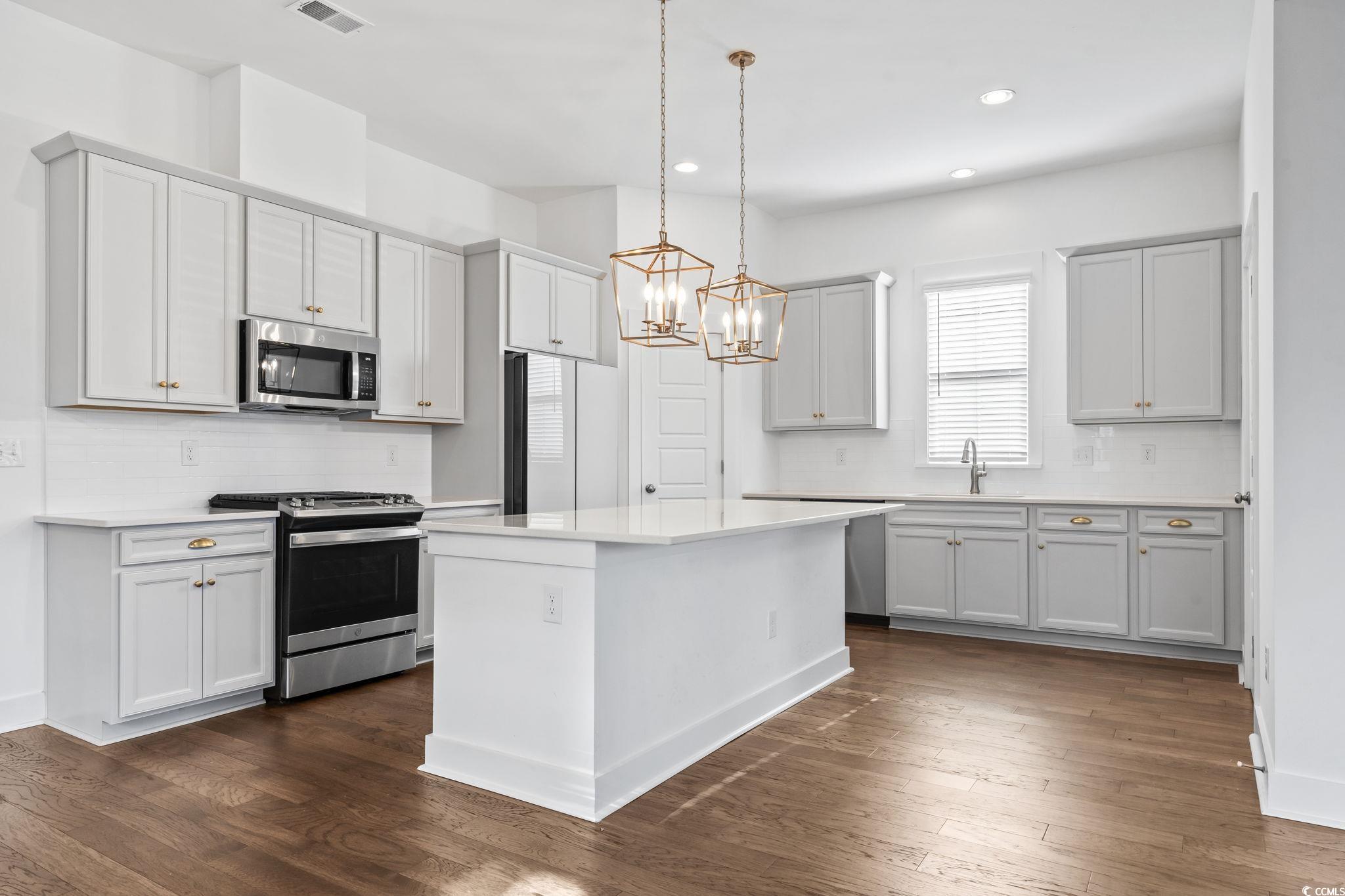 1524 Sayebrook Parkway Myrtle Beach, SC 29588 - Photo 11 of 40 Kitchen featuring backsplash, appliances with stainless steel finishes, hanging light fixtures, recessed lighting, and a kitchen island