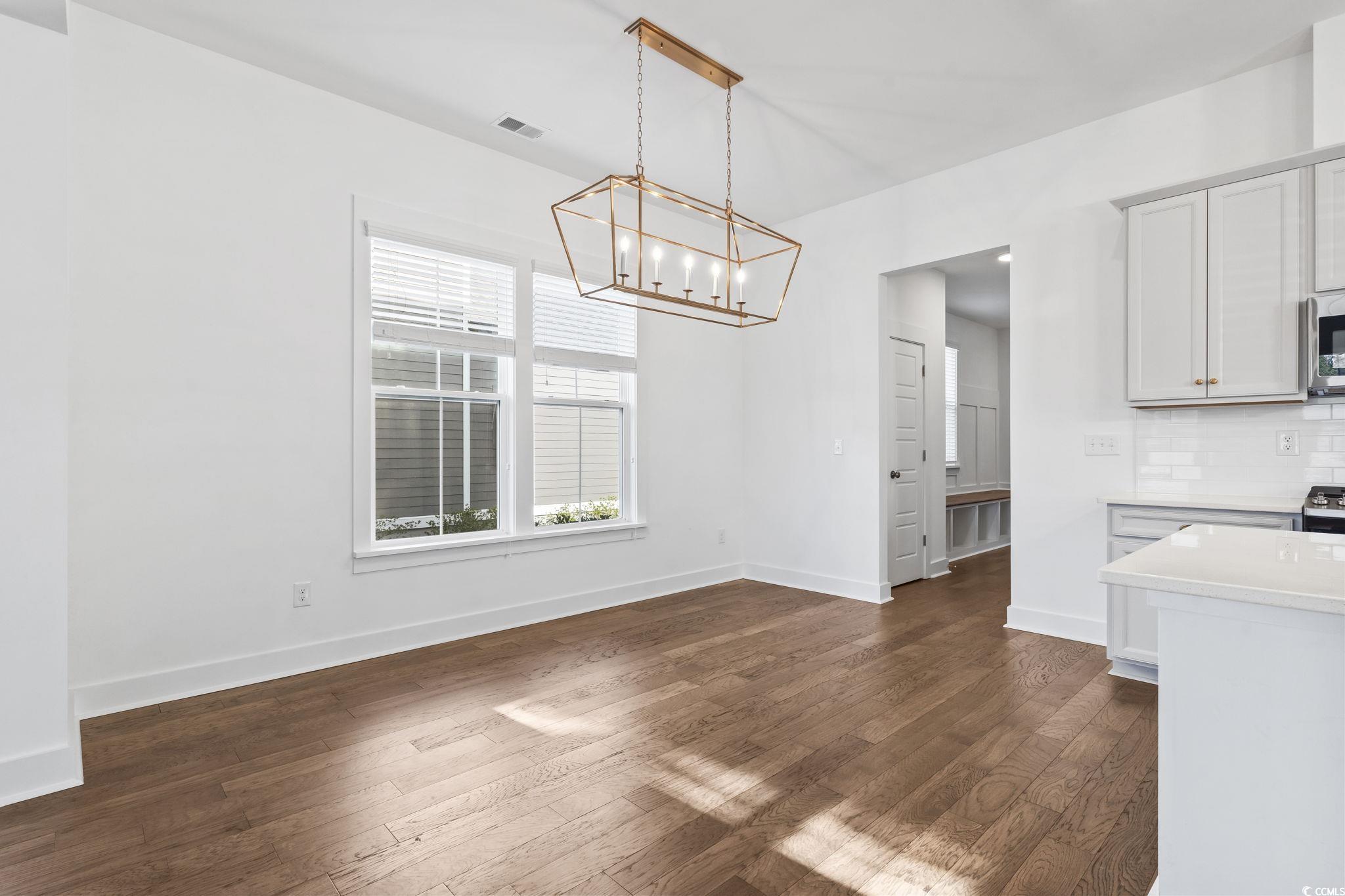 1524 Sayebrook Parkway Myrtle Beach, SC 29588 - Photo 12 of 40 Unfurnished dining area featuring dark wood-type flooring and a chandelier