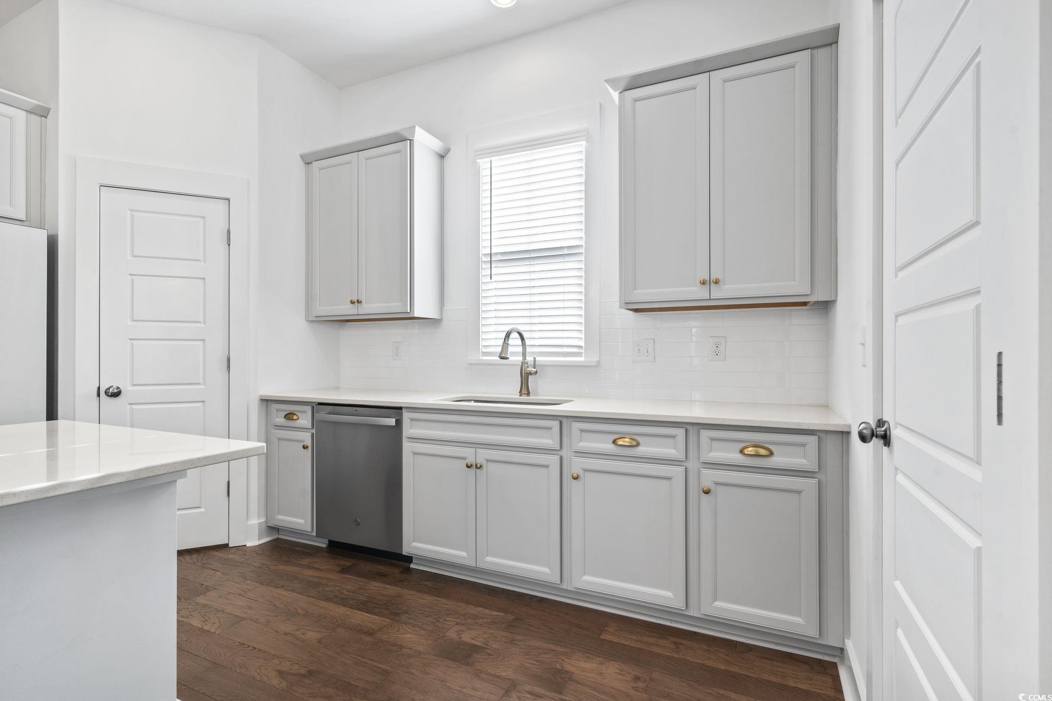 1524 Sayebrook Parkway Myrtle Beach, SC 29588 - Photo 13 of 40 Kitchen featuring dishwasher, light stone countertops, backsplash, dark wood-type flooring, and freestanding refrigerator