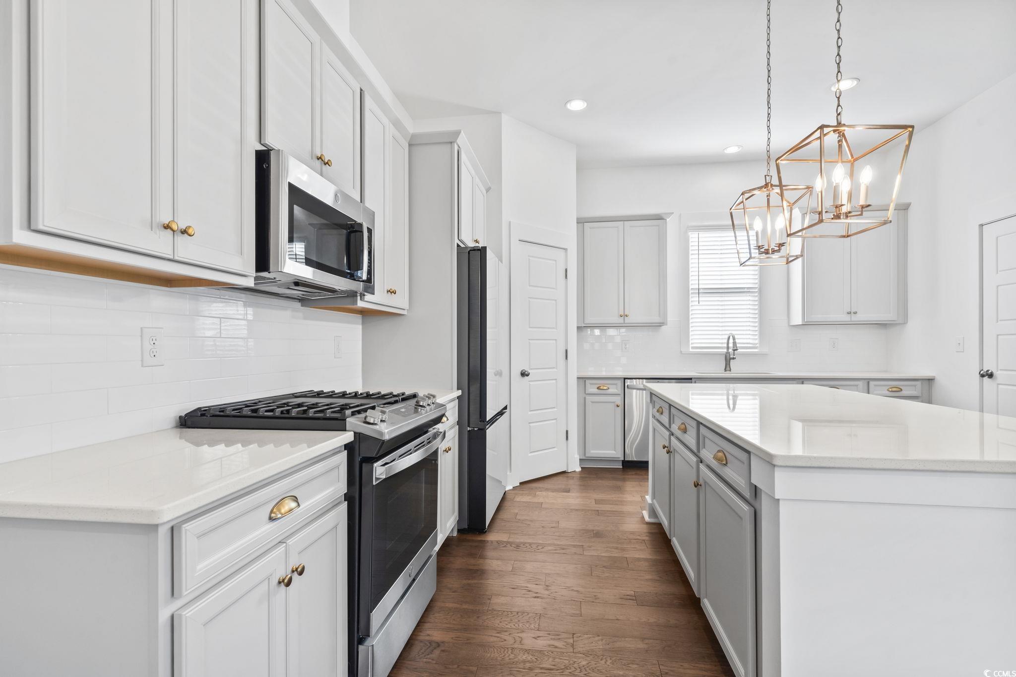 1524 Sayebrook Parkway Myrtle Beach, SC 29588 - Photo 14 of 40 Kitchen with appliances with stainless steel finishes, hanging light fixtures, backsplash, light stone countertops, and recessed lighting