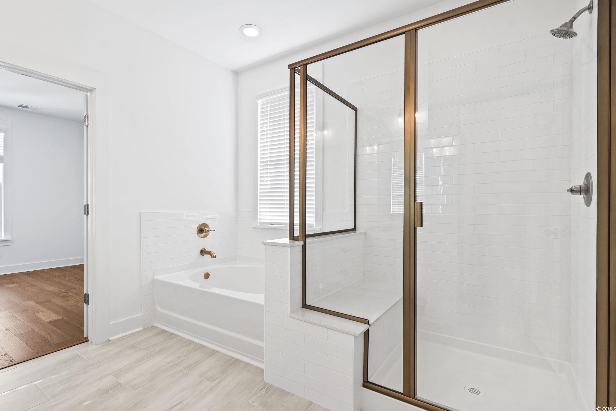 1524 Sayebrook Parkway Myrtle Beach, SC 29588 - Photo 25 of 40 Bathroom with a garden tub, a stall shower, and light wood-style flooring