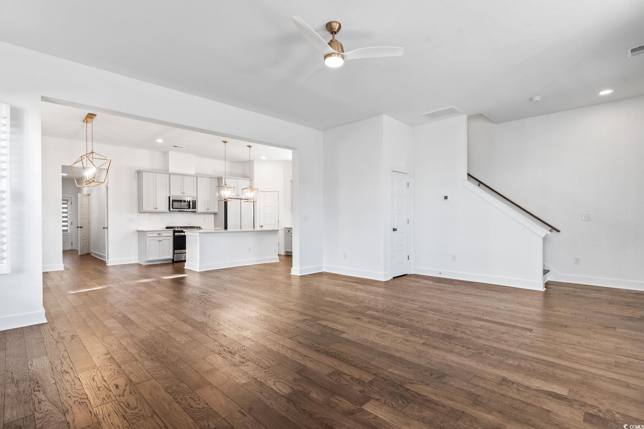 1524 Sayebrook Parkway Myrtle Beach, SC 29588 - Photo 8 of 40 Unfurnished living room with a chandelier, recessed lighting, dark wood-type flooring, a ceiling fan, and stairway