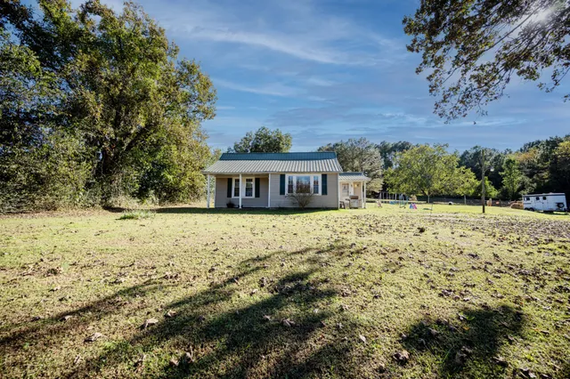 a view of house with yard and trees