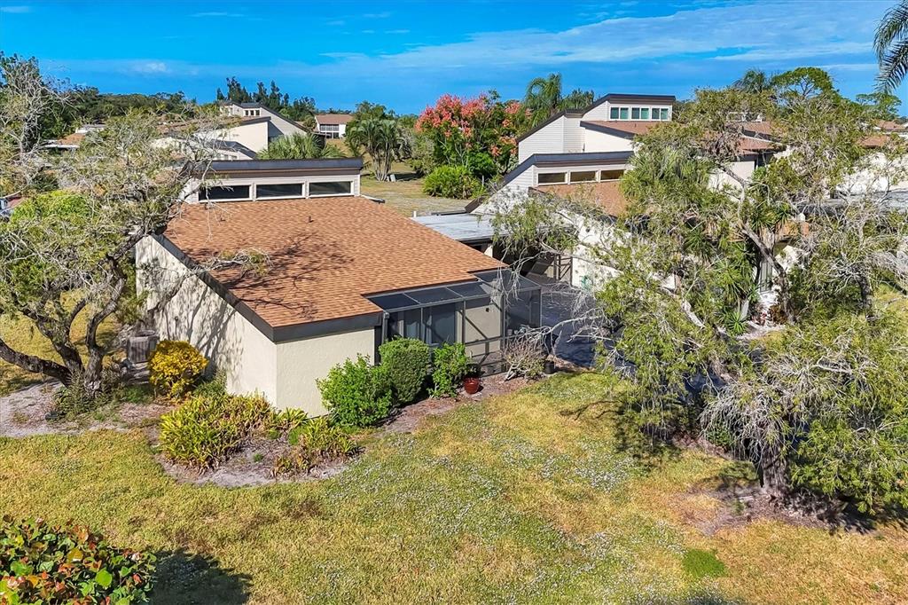 a view of a house with a yard and large trees