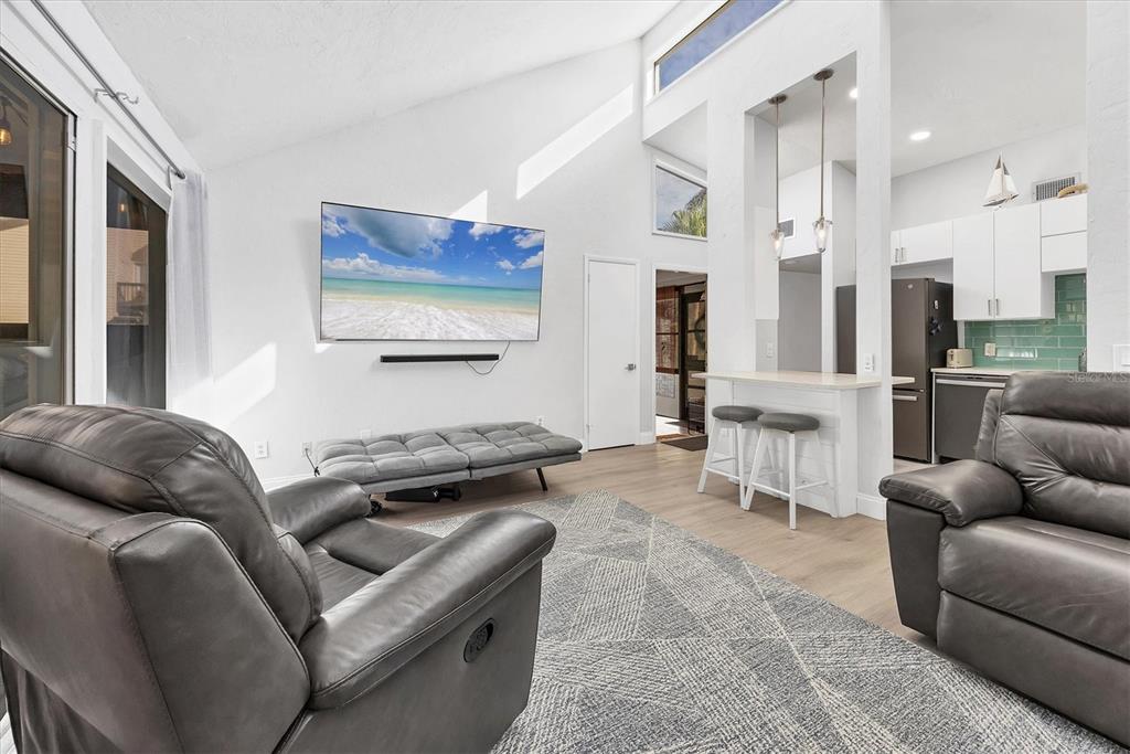 680 White Pine Tree Road, Unit 61 Venice, FL 34285 - Photo 4 of 40 a living room with furniture a rug and white walls