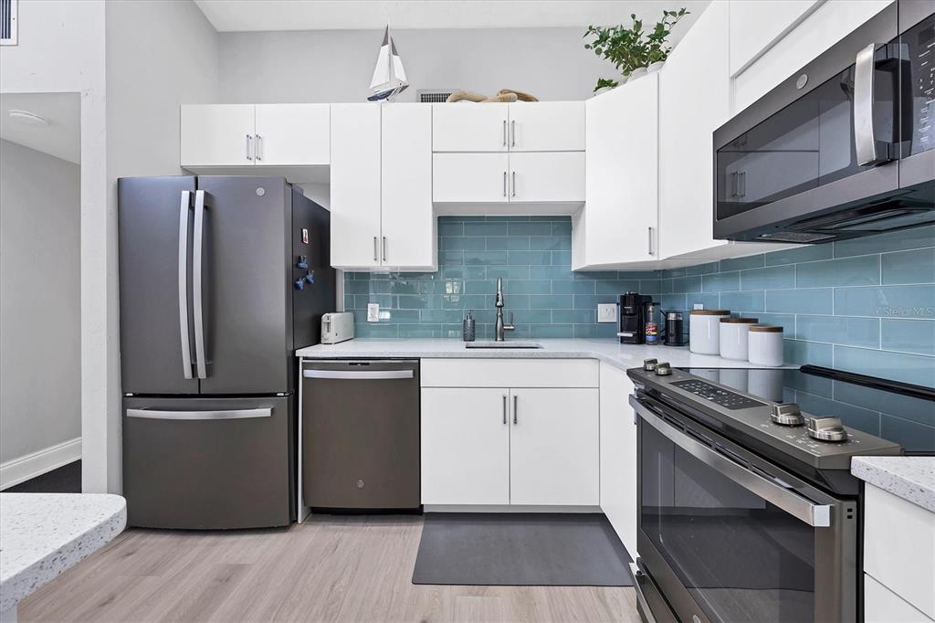 680 White Pine Tree Road, Unit 61 Venice, FL 34285 - Photo 8 of 40 a kitchen with stainless steel appliances a refrigerator sink and microwave