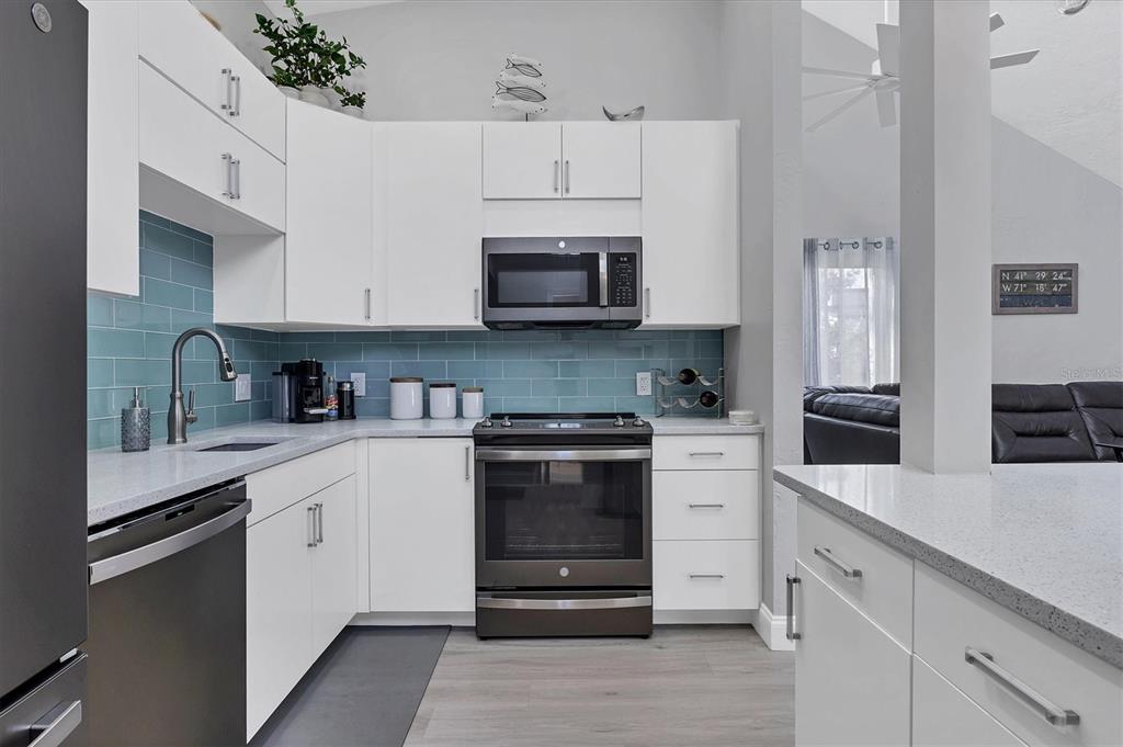 680 White Pine Tree Road, Unit 61 Venice, FL 34285 - Photo 9 of 40 a kitchen with granite countertop white cabinets and stainless steel appliances