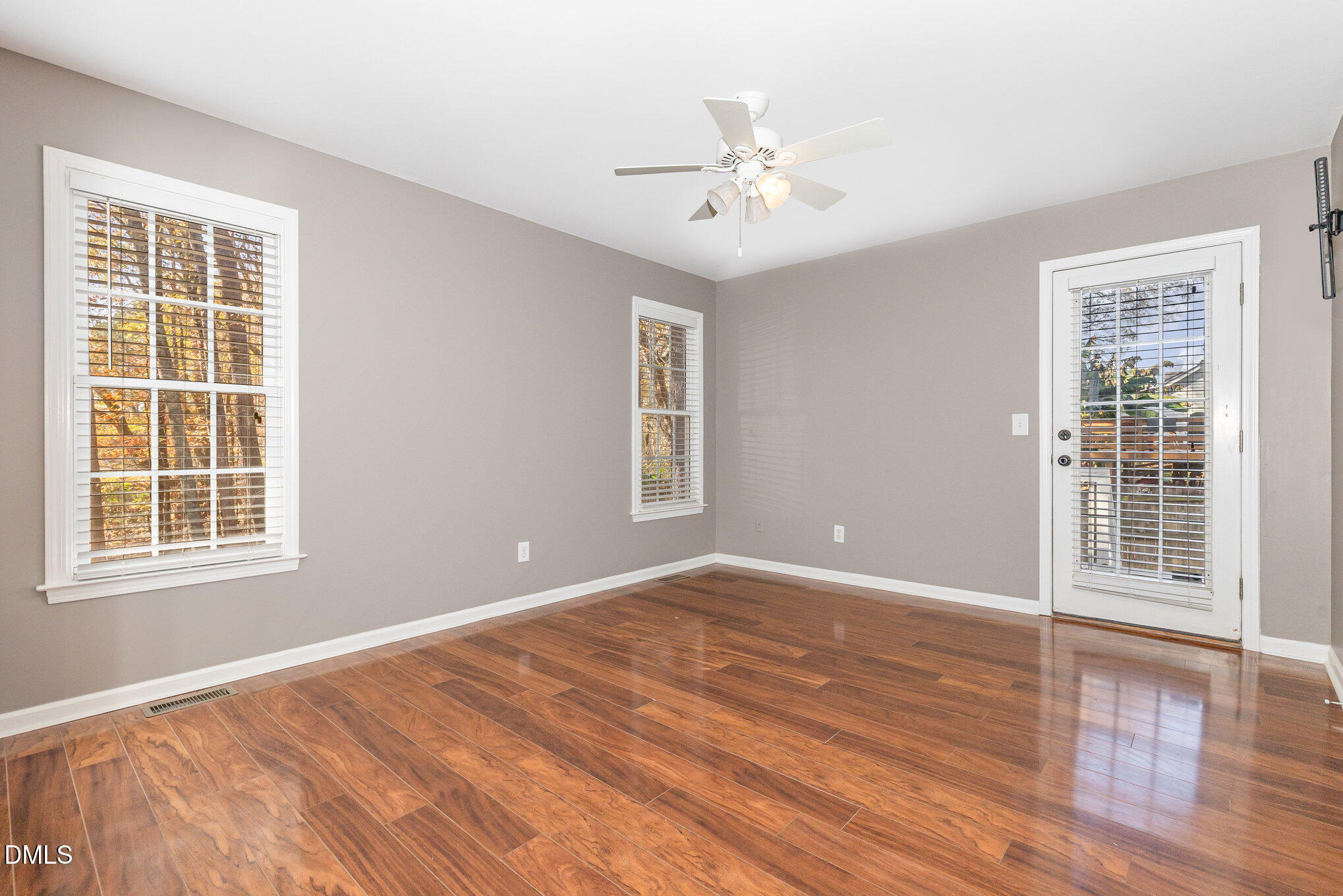 2813 Glastonbury Road Apex, NC 27539 - Photo 13 of 21 a view of an empty room with wooden floor and a window