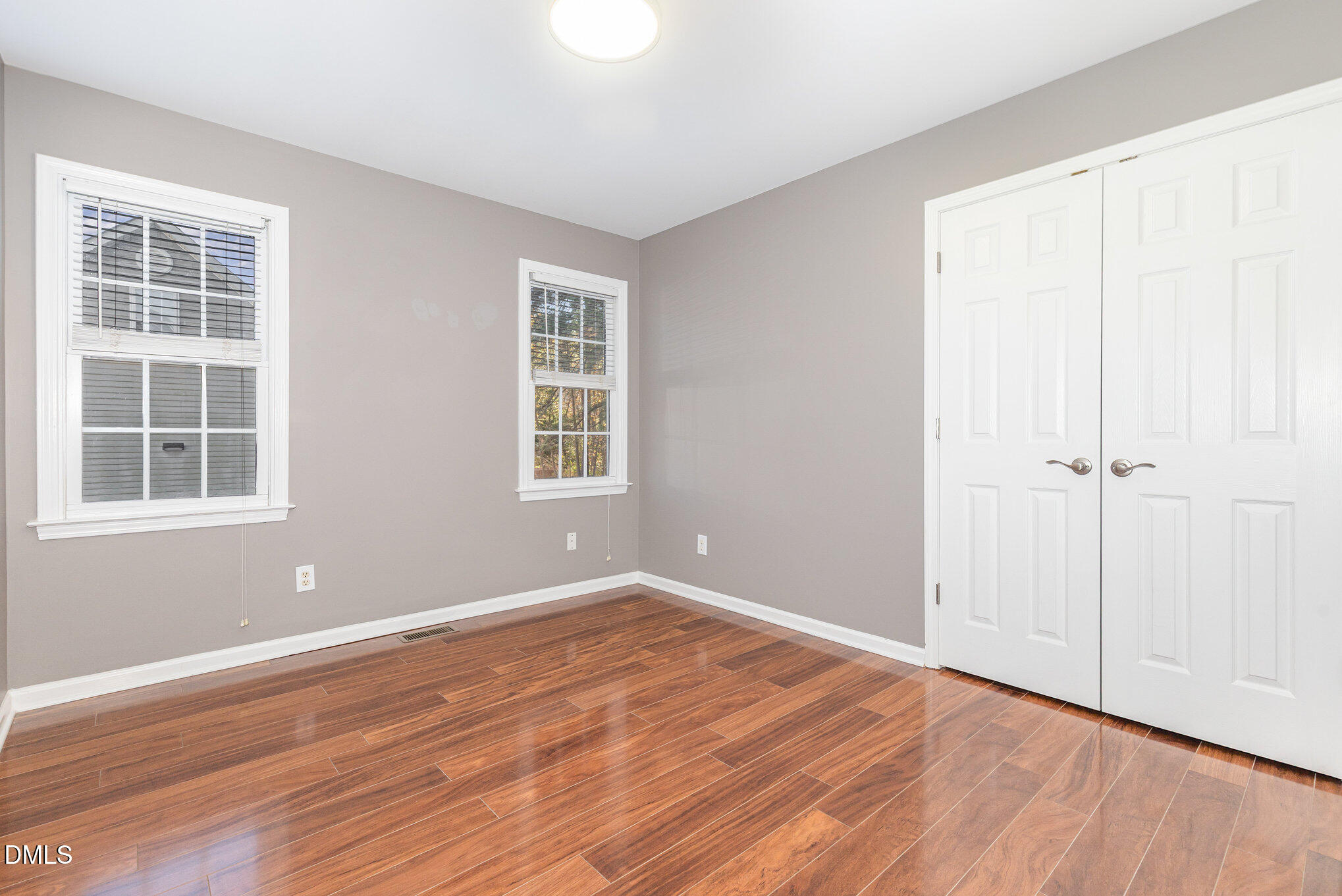 2813 Glastonbury Road Apex, NC 27539 - Photo 15 of 21 an empty room with wooden floor and windows