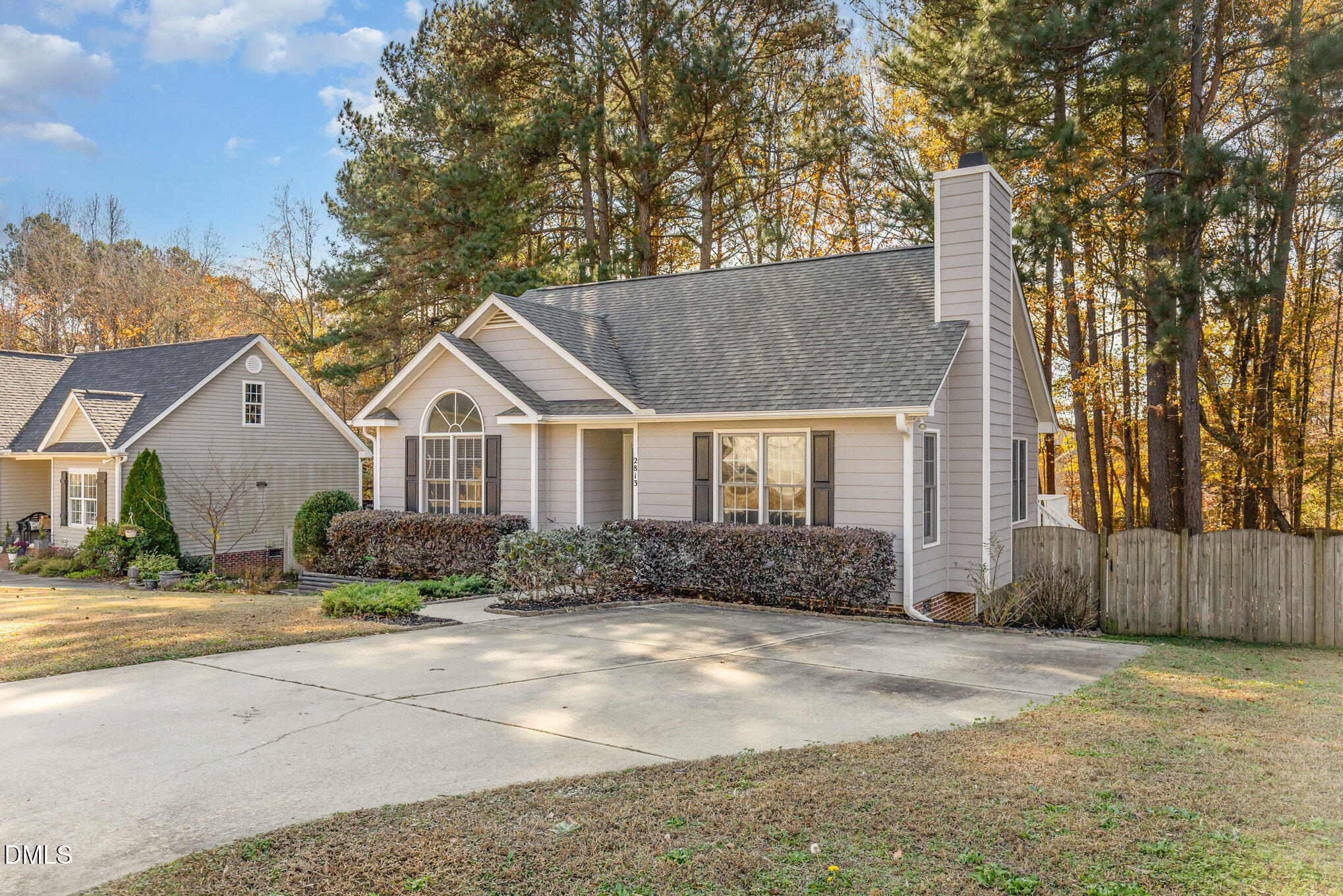 2813 Glastonbury Road Apex, NC 27539 - Photo 2 of 21 a view of a white house with a large trees with wooden fence