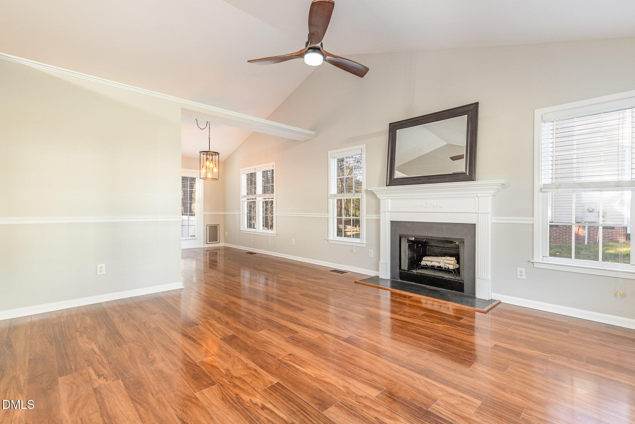 2813 Glastonbury Road Apex, NC 27539 - Photo 6 of 21 a view of a livingroom with wooden floor a fireplace and windows