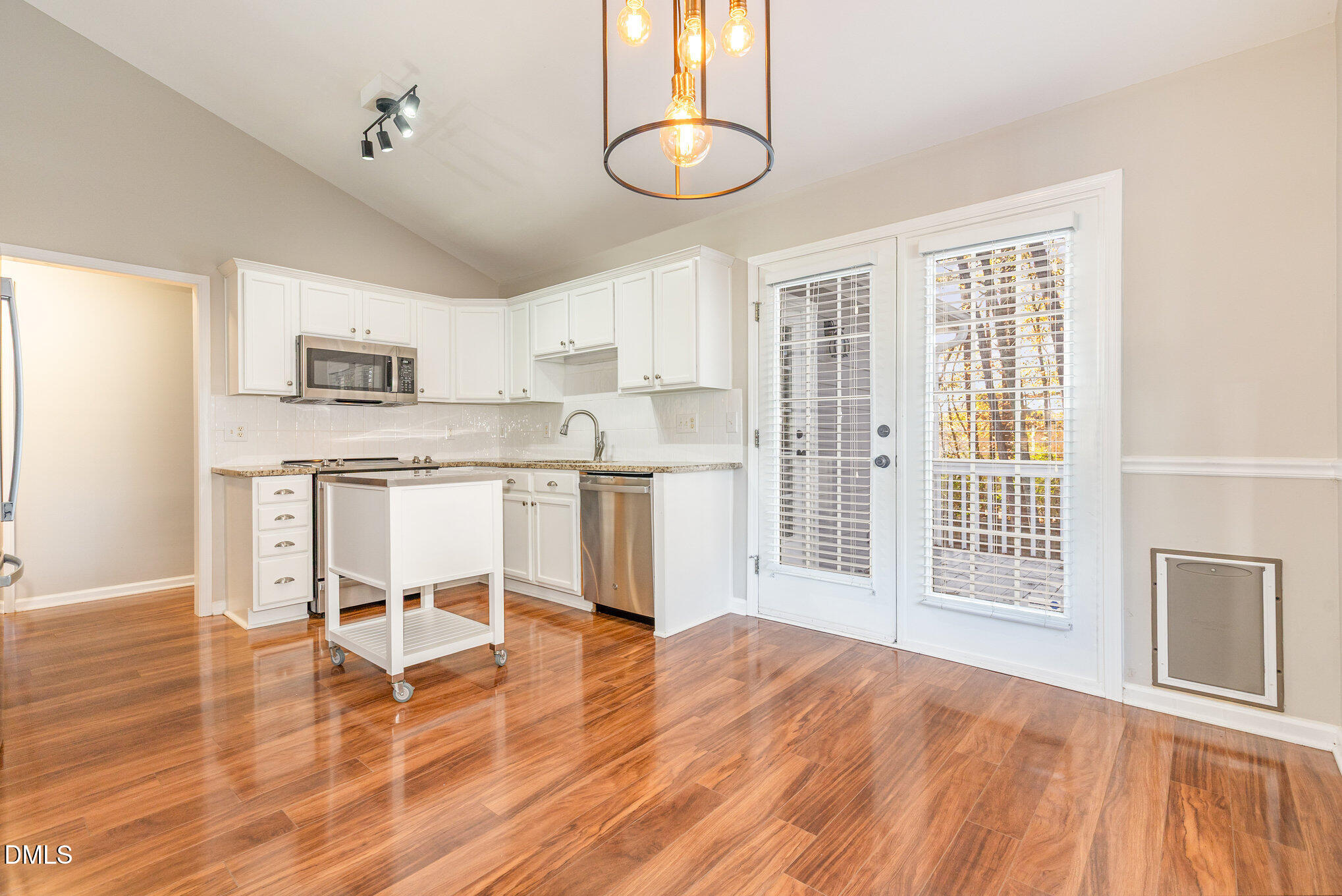 2813 Glastonbury Road Apex, NC 27539 - Photo 8 of 21 a kitchen with stainless steel appliances granite countertop a stove top oven a sink dishwasher and white cabinets with wooden floor