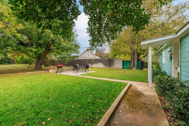 a front view of a house with a yard and trees
