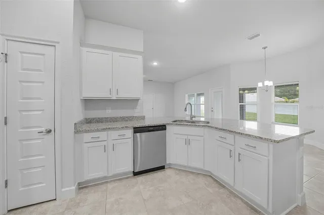 a kitchen with granite countertop white cabinets and white stainless steel appliances