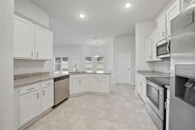 a kitchen with white cabinets stainless steel appliances and a sink