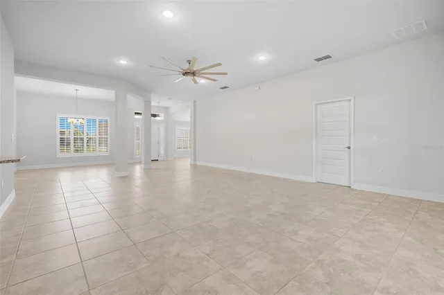 an empty room with kitchen and windows