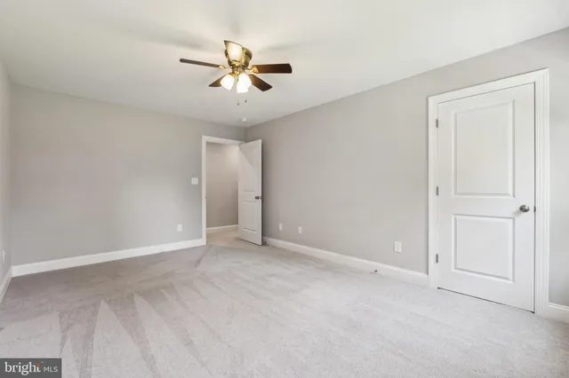 a view of an empty room and chandelier fan