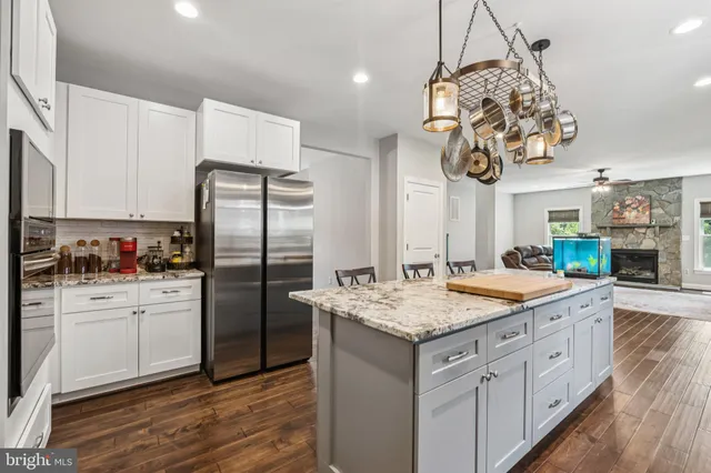 a kitchen with stainless steel appliances granite countertop a sink refrigerator and cabinets