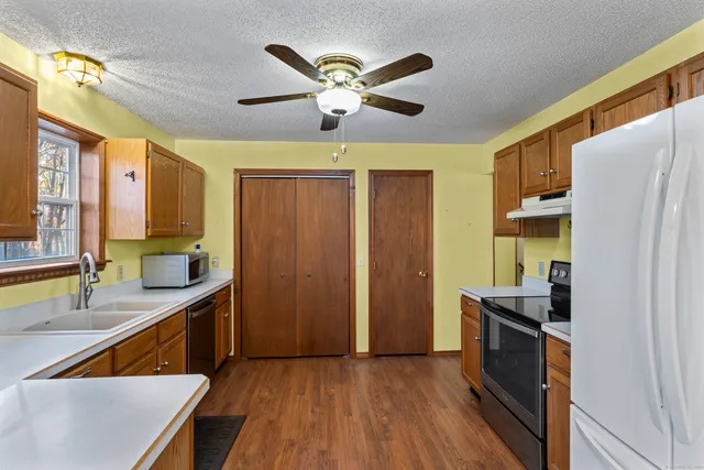 a kitchen with stainless steel appliances granite countertop a refrigerator a sink dishwasher and a stove