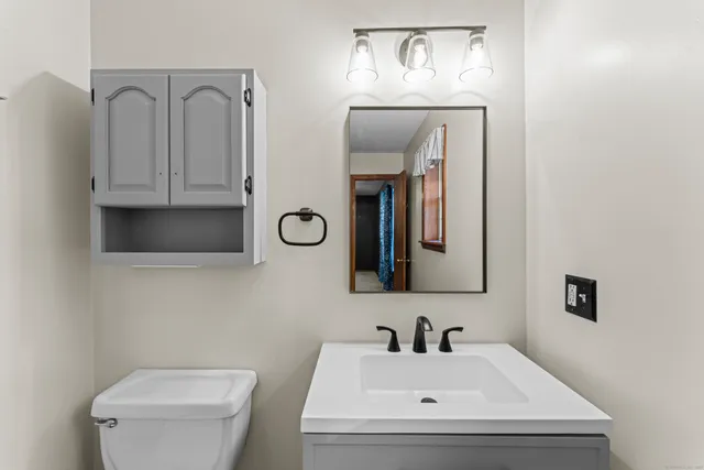 a bathroom with a toilet sink and mirror